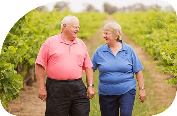 Elderly couple walk through vineyard